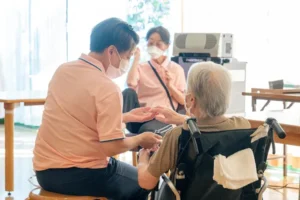 かーさ・びあんかで職員と入居者が手を取り合う様子